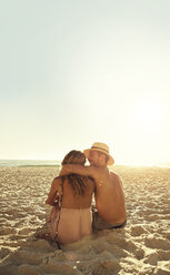 Affectionate young couple hugging on sunny summer beach - CAIF04820