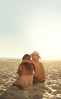 Zärtliches junges Paar, das sich am sonnigen Sommerstrand umarmt - CAIF04820