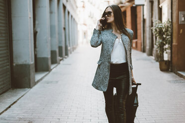 Young tourist on the phone walking down the street - OCAF00163