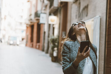 Laughing young woman receiving good news - OCAF00165