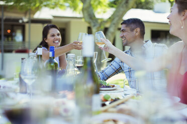 Friends toasting each other at dinner outdoors - CAIF04841