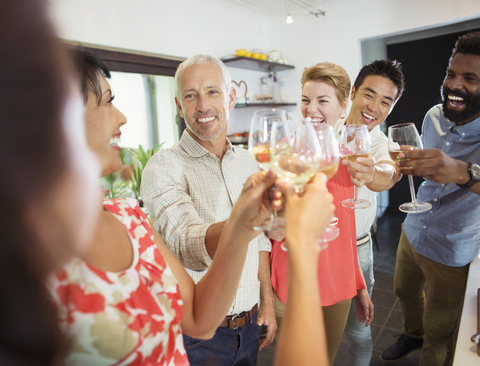 Freunde stoßen auf einer Party aufeinander an, lizenzfreies Stockfoto