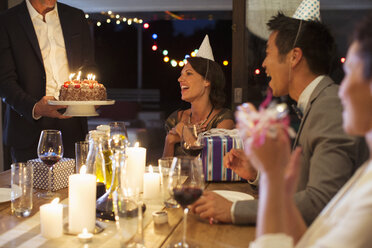 Man serving birthday cake at party - CAIF04859