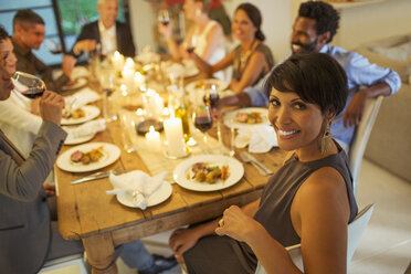 Woman smiling at dinner party - CAIF04870