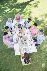 Freunde essen gemeinsam am Tisch im Freien - CAIF04907