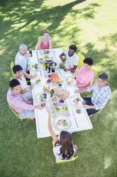 Friends eating together at table outdoors - CAIF04907