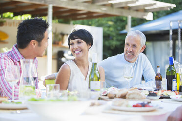 Friends relaxing at table outdoors - CAIF04910