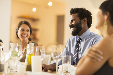 Lachende Freunde auf einer Dinnerparty, lizenzfreies Stockfoto