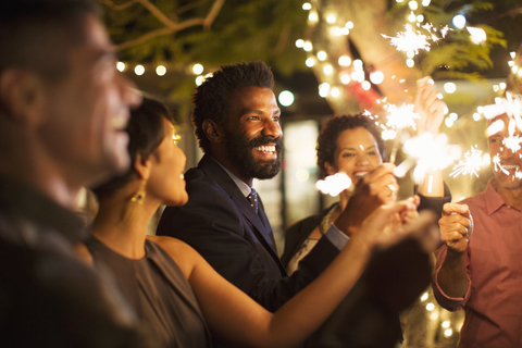 Friends playing with sparklers at party stock photo