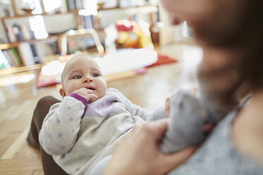 Mother holding baby daughter in lap - CAIF04927