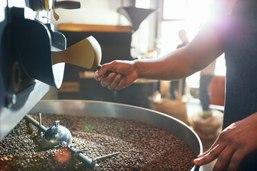 Männlicher Kaffeeröster beim Rösten von Kaffeebohnen - CAIF04945