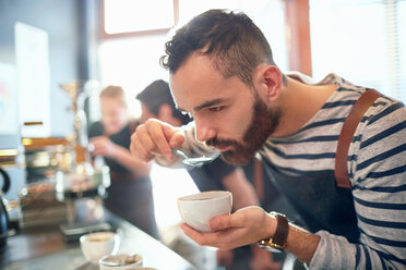 Männlicher Kaffeeröster beim Verkosten von Kaffee - CAIF04946