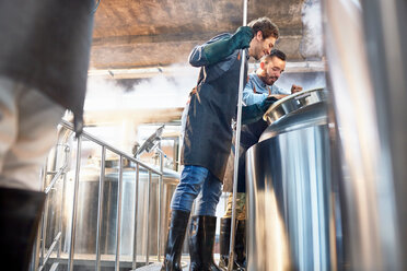 Männliche Brauer bei der Kontrolle des Bottichs in der Brauerei - CAIF04963