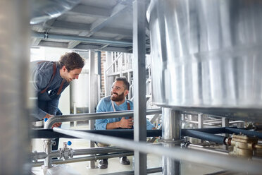 Männliche Brauer im Gespräch mit dem Bottich in der Brauerei - CAIF04976