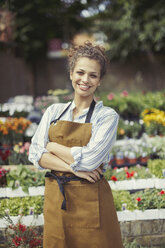 Portrait smiling, confident female florist working at flower shop - CAIF04991
