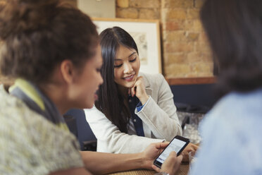 Young female friends using smart phone in cafe - CAIF04992