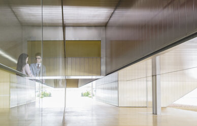 Geschäftsleute im Gespräch am Fenster in einer modernen Büro-Lobby - CAIF05040