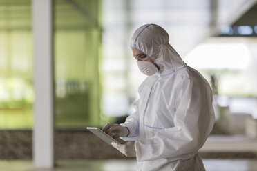 Wissenschaftler im sauberen Anzug mit digitalem Tablet - CAIF05054