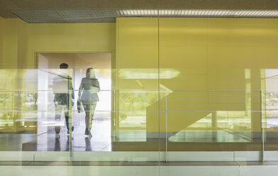 Geschäftsleute gehen in einem modernen Bürokorridor - CAIF05056