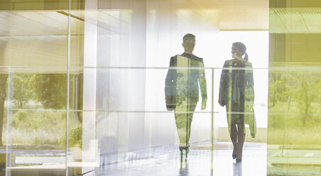 Silhouette Geschäftsmann und Geschäftsfrau zu Fuß in modernen Bürokorridor - CAIF05062