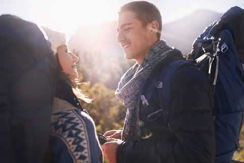 Junges Paar mit Rucksäcken beim Wandern, lizenzfreies Stockfoto