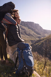 Young couple with backpacks looking at sunny view - CAIF05151