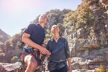 Junger Mann und Frau beim Klettern, Blick auf sonnige Felsen - CAIF05164