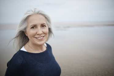 Portrait smiling senior woman on beach - CAIF05165