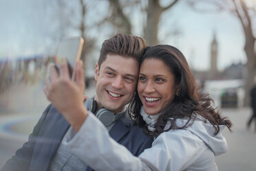 Lächelndes Paar macht Selfie mit Fotohandy im Stadtpark - CAIF05190