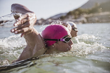 Entschlossene Freiwasserschwimmerin schwimmt im sonnigen Meer - CAIF05214