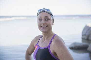 Portrait smiling confident female open water swimmer at ocean - CAIF05229