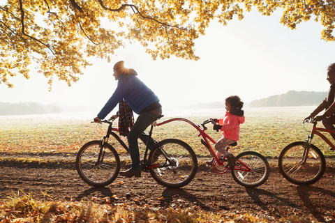 Vater und Tochter Radfahren mit Anhänger Fahrrad in sonnigen Herbst Park, lizenzfreies Stockfoto