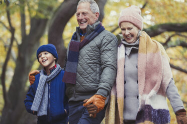 Großeltern gehen mit Enkel im Herbstpark spazieren - CAIF05318