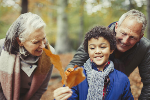 Großeltern und Enkel halten Herbstblatt - CAIF05341