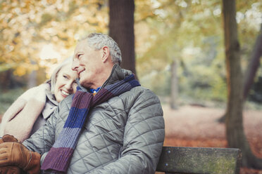 Zärtliches älteres Paar auf einer Bank im Herbstpark - CAIF05342
