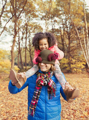 Porträt spielerische Tochter zieht Strumpfmütze über Väter Augen im Herbst Park - CAIF05343
