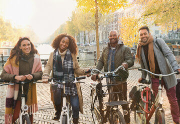 Porträt lächelnd Freunde Radfahren auf städtischen Herbst Straße, Amsterdam - CAIF05366