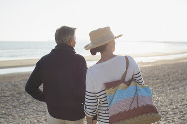 Älteres Paar auf dem Weg zum Sonnenuntergang am Strand - CAIF05386