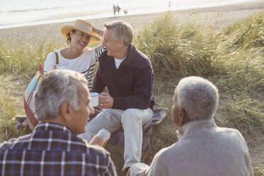 Ältere Paare trinken Kaffee und entspannen sich am Strand - CAIF05400