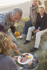 Ältere Paare beim Grillen und Weintrinken am Strand - CAIF05412