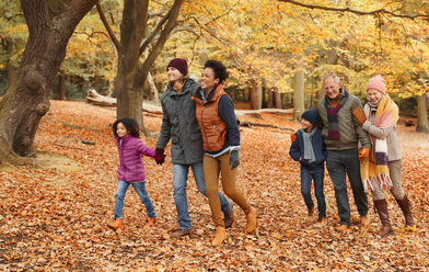 Mehrgenerationenfamilie beim Spaziergang im Herbstpark - CAIF05441