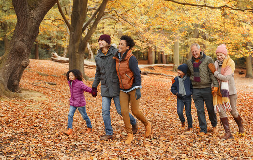 Mehrgenerationenfamilie beim Spaziergang im Herbstpark - CAIF05441