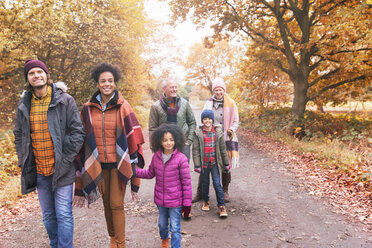 Mehrgenerationen-Familie beim Spaziergang auf einem Weg im Herbstpark - CAIF05450