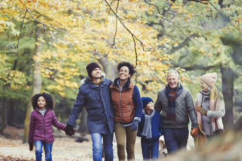 Mehrgenerationenfamilie beim Spaziergang im Herbstwald - CAIF05451
