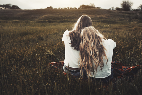 Ruhige Teenager-Schwestern in weißen T-Shirts auf einem ländlichen Feld, lizenzfreies Stockfoto