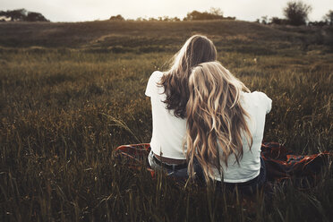 Ruhige Teenager-Schwestern in weißen T-Shirts auf einem ländlichen Feld - CAIF05491