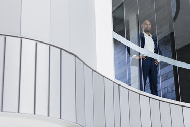 Selbstbewusster CEO-Geschäftsmann, der in einem modernen Bürofenster steht - CAIF05497