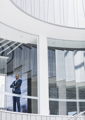 Porträt selbstbewusster, seriöser CEO-Geschäftsmann, der an einem modernen Bürofenster steht - CAIF05524