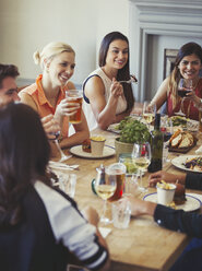 Freunde unterhalten sich und essen am Restauranttisch - CAIF05552