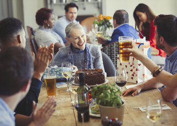 Frau genießt Geburtstag mit Freunden am Restauranttisch - CAIF05560